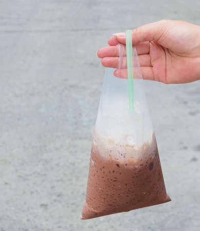 Drink and Beverage, Hand Hodling Thai Iced Coffee or Iced Chocolate in Plastic Bag.の写真素材