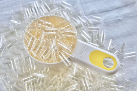 Medical Concept, Close Up Empty Gelatin Capsuleson in A Measuring Spoon Used to Enclose Medicines, Powdered Drugs, Herbs and Miniature Pellets in A Relatively Stable Shell.の写真素材