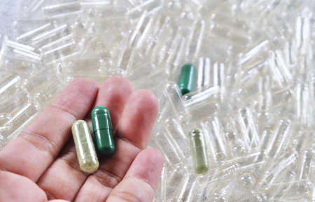 Medical Concept, Hand Holding Green Capsules of Herbal Medicine Use of Medicinal Plants.の写真素材