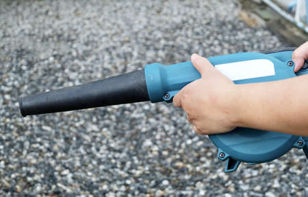 Hand Holding Blue Air Blower, Use to Remove Dust From The Electrical Machine and Leaves in A Garden.の写真素材