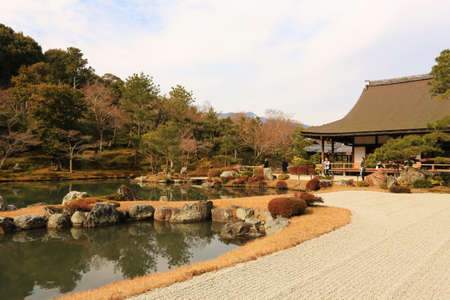 In middle of forest, mountain stands in front of an ancient house.のeditorial素材