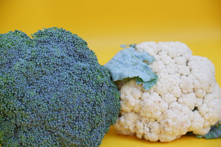 Broccoli and cauliflower on a yellow background. Vegetarian food.
