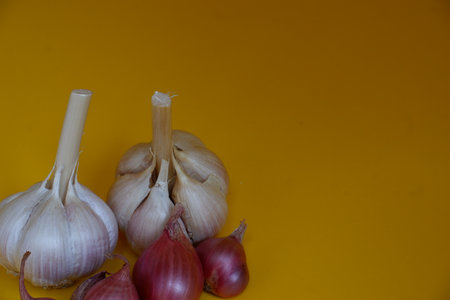 Garlic and onion on a yellow background. Ingredients for cooking.の写真素材