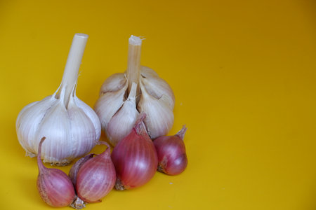 Garlic and shallot on a yellow background. Selective focus.の写真素材
