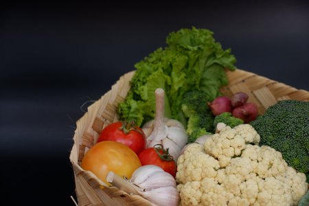 Fresh vegetables in a basket on a black background. Healthy food.の写真素材