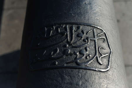 Arabic inscription on metal surface of ottoman naval historical cannon in Besiktas, Istanbul, Turkey.のeditorial素材
