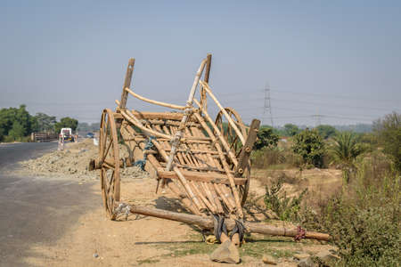 A bullock cart is standing by a road side.