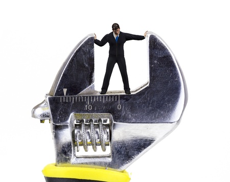 wrench crushing a tiny man closeupの写真素材