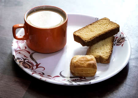 Indian milk tea with toast, tea cup, orange tea cup, teatime