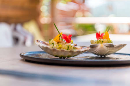 Fresh scallops tartar with small pieces of avocado,mango and oranges