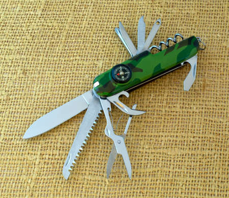 Multifunctional pen-knife close-up on burlap background