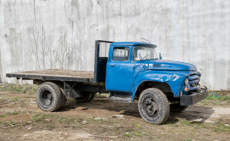Old broken truck in front of high wallの写真素材