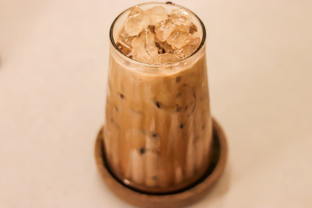 High-angle view of glass of an iced coffee with creamy milk. Cold brew coffee drink with ice.の写真素材
