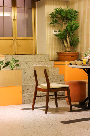 Interior design of stylish dining room interior with family wooden table, modern chairs, plate with nuts, salt and pepper shakers. Concrete floorの写真素材