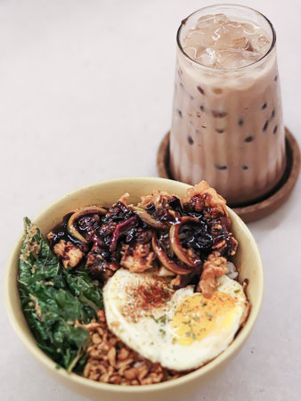 a glass of coffee with ice and boiled noodles filled with eggs and vegetablesの写真素材