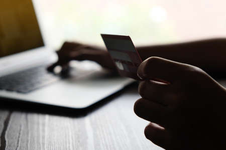 Online payment,Manâs hands holding the credit card and using labtop for online shopping.の写真素材