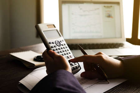 Close up of Hand man doing finances and calculate on desk about cost at home office.Savings,...