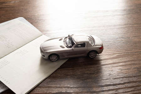 Miniature car model and Financial statement on wooden table, Buying a carの写真素材