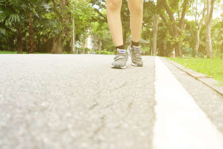 A woman jogging in the park in the evening light