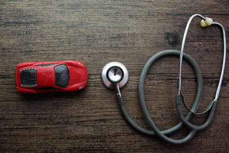 Stethoscope and car on the wooden background, Concept of car check-up, repair and maintenance.の写真素材