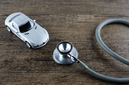 Stethoscope and car on the wooden background, Concept of car check-up, repair and maintenance.の写真素材