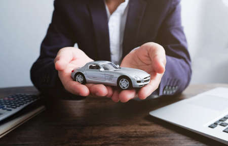 Miniature car model on hand, Auto dealership and rental conceptの写真素材