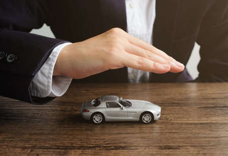 Car insurance concept, Hand man protect a car on the table.の写真素材