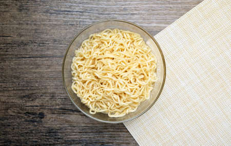 instant noodle in the glass bowl on the wooden tableの写真素材