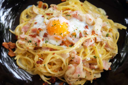 Close up of Spaghetti Carbonara with egg in white plate on the wooden table.の写真素材