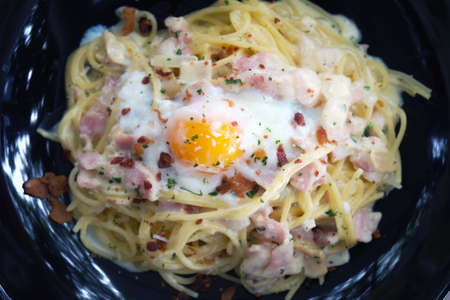 Close up of Spaghetti Carbonara with egg in white plate on the wooden table.の写真素材