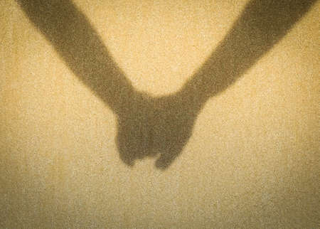 Shadow of Couple holding hand on the beachの写真素材