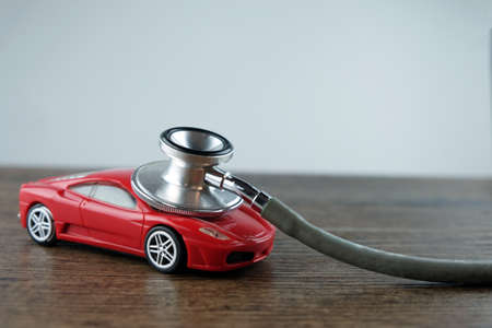 Stethoscope and car on the wooden table, Concept of car check-up, repair and maintenance.の写真素材