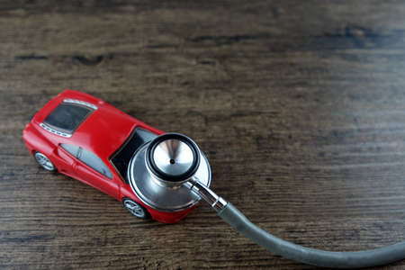 Stethoscope and car on the wooden table, Concept of car check-up, repair and maintenance.の写真素材