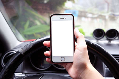 Closeup of hand holding smart phone in a car