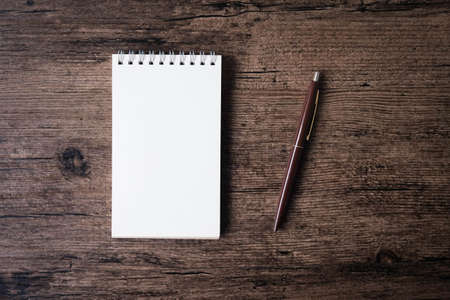 Top view image of open notebook with blank page and pen on the wooden table.の写真素材