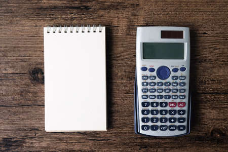 Top view image of blank page notebook and calculator on the wooden table.の写真素材