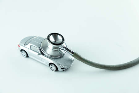 Stethoscope checking up the car on white background, Concept of car check up, repair and maintenance.の写真素材