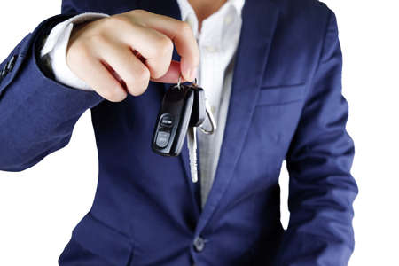 Businessman offering a car key,Close up of hand showing key of automobile.の写真素材