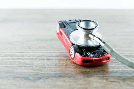 Stethoscope checking up the car on wooden table, Concept of car check up, repair and maintenance.の写真素材