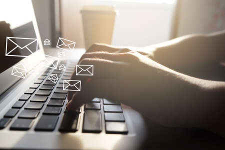 Close up of woman hand using laptop with email icon for sending email concept.selective focus.の写真素材