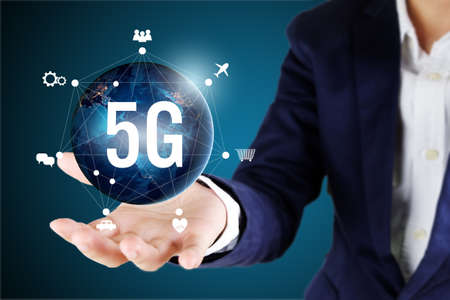Businessman holding global with 5G network icons.の写真素材