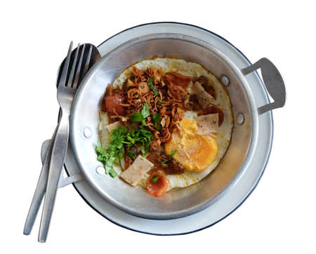 Thai Breakfast - Close up of fried egg in the pan in the white plate isolatedの写真素材