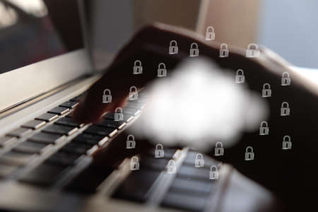 Cloud and lock icon on hand and keyboard background.Cloud computing and network security concept