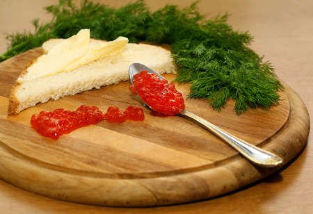 Close-up of a delicious sandwich, red caviar, dill, spoon, tableの写真素材