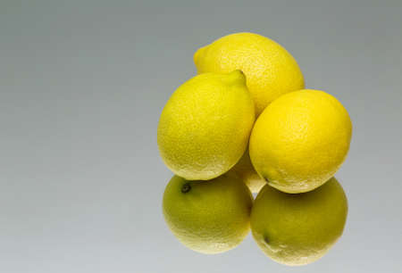 fresh yellow lemons lying on a mirror. reflection. fruitの写真素材