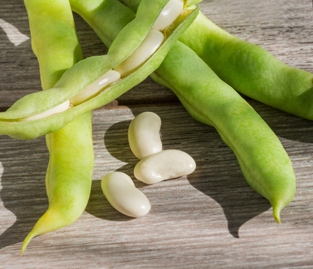 green pod white beans close-up on a wooden table. vegetables, cereals. macro.