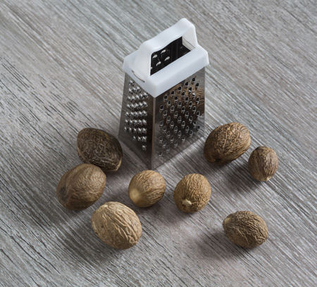 Grater, nutmeg closeup on a wooden surface. cooking ingredients. macroの写真素材