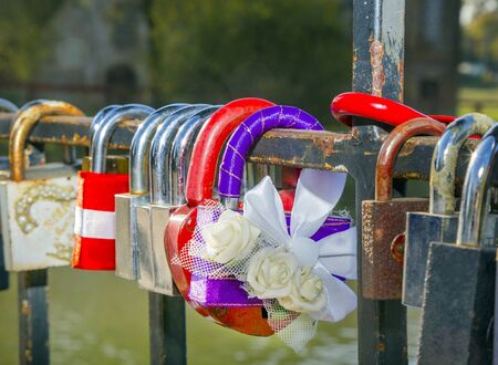 colorful locks hanging on the railing of the bridge. metal, wedding, tradition, ritual, love, closeupの写真素材