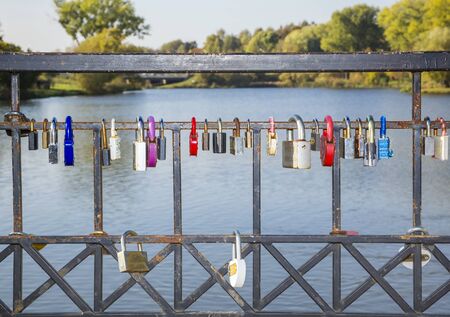 colorful locks hanging on the railing of the bridge. metal, wedding, tradition, ritual, loveのeditorial素材
