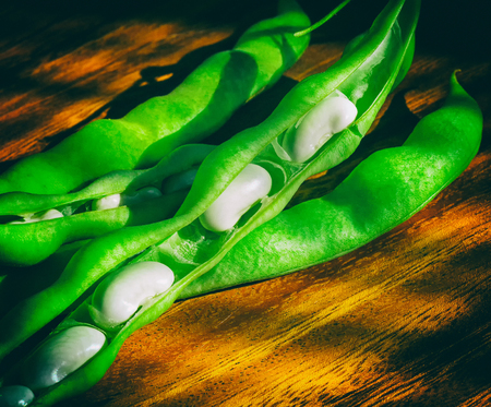 green pod white beans close-up on a wooden table. vegetables, cereals. macro.の写真素材